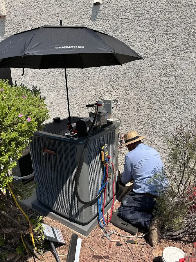 HVAC technician performing outdoor AC maintenance in Oakfield